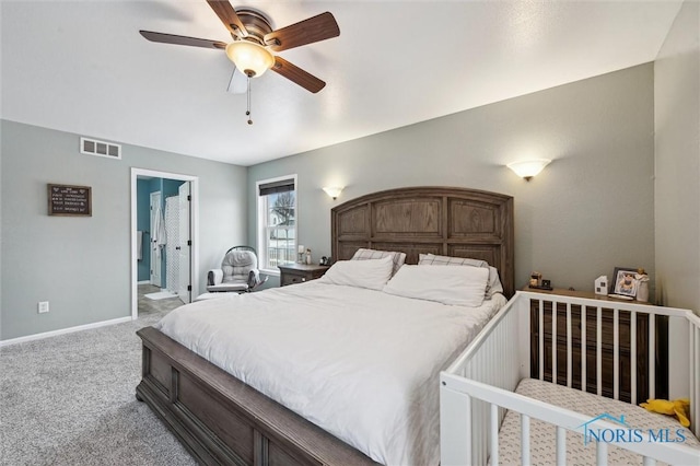 carpeted bedroom featuring ceiling fan and ensuite bath