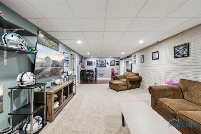 living room with carpet flooring and a paneled ceiling