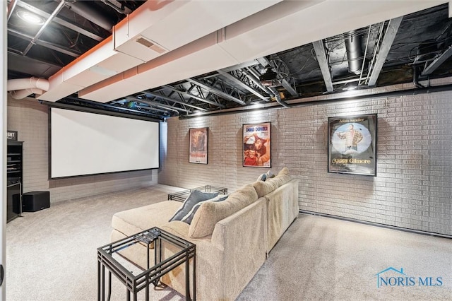 home theater room with brick wall and carpet