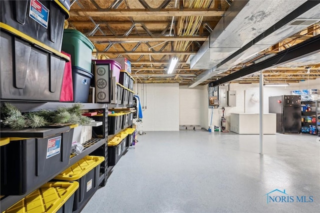 basement featuring black fridge and electric panel