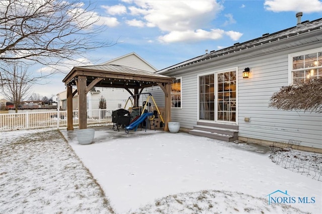 snow covered patio with a gazebo and grilling area