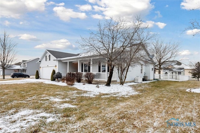 view of front of property featuring a garage, a lawn, central air condition unit, and a porch