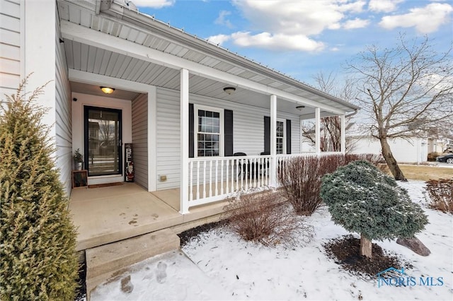 snow covered property entrance featuring covered porch