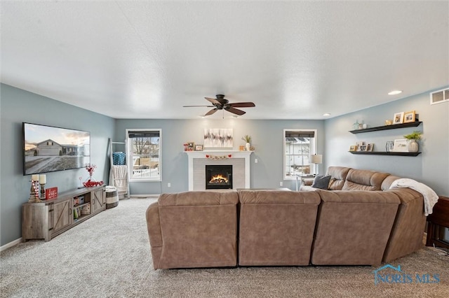 carpeted living room with ceiling fan and a textured ceiling