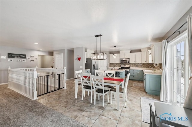 tiled dining area featuring an inviting chandelier and sink