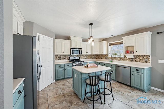 kitchen featuring appliances with stainless steel finishes, white cabinetry, hanging light fixtures, a center island, and a kitchen bar