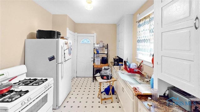 kitchen featuring white cabinetry, sink, and white appliances