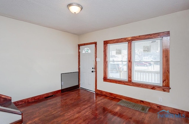 unfurnished room with dark hardwood / wood-style floors and a textured ceiling