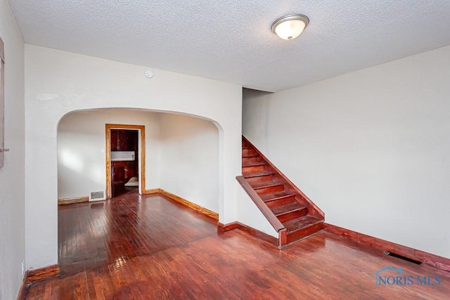 spare room with dark hardwood / wood-style flooring and a textured ceiling