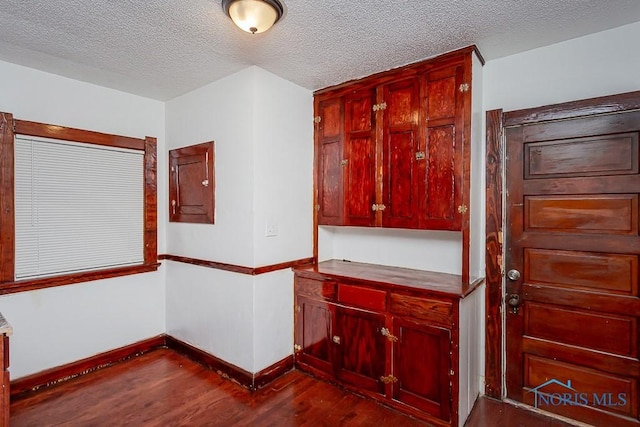 kitchen with dark hardwood / wood-style floors and a textured ceiling