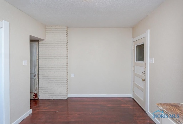 interior space featuring dark hardwood / wood-style floors and a textured ceiling