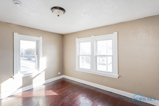 empty room with hardwood / wood-style flooring and a textured ceiling