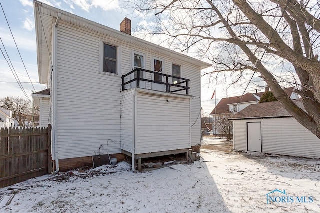 snow covered property with a storage shed