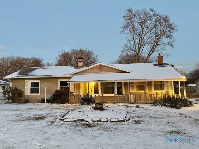 snow covered house with covered porch