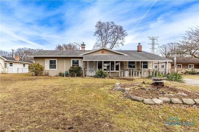 ranch-style house featuring covered porch and a front yard