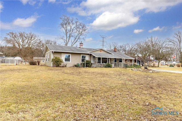 view of front of home with a porch, fence, and a front lawn