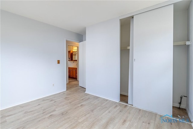 unfurnished bedroom with a closet and light wood-style flooring