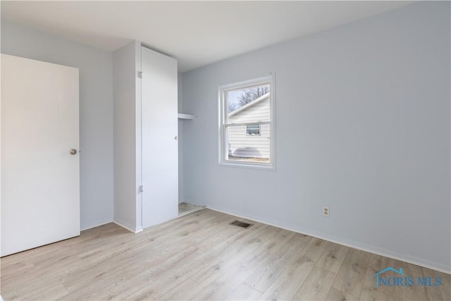 unfurnished bedroom with visible vents and light wood finished floors