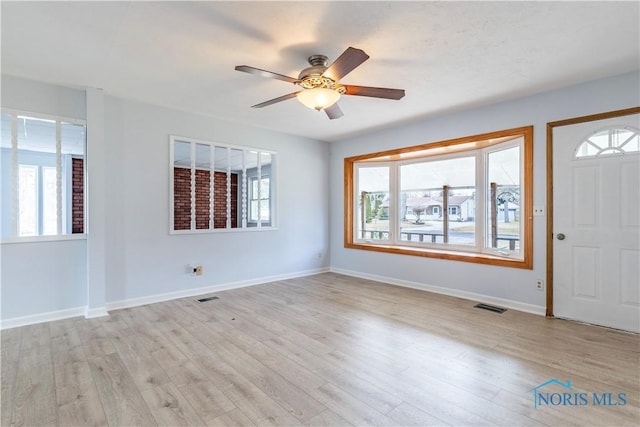 foyer entrance with light wood-style flooring, visible vents, and baseboards