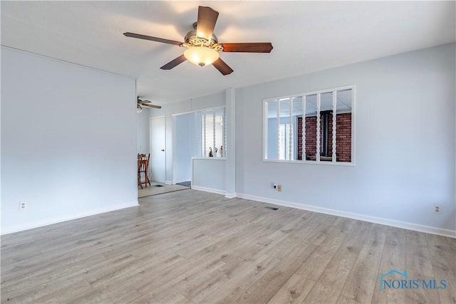 unfurnished room with light wood-style flooring and baseboards