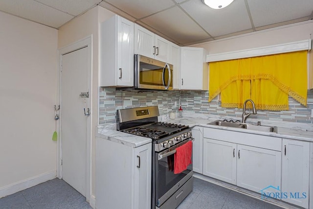 kitchen with sink, white cabinetry, a paneled ceiling, tasteful backsplash, and stainless steel appliances