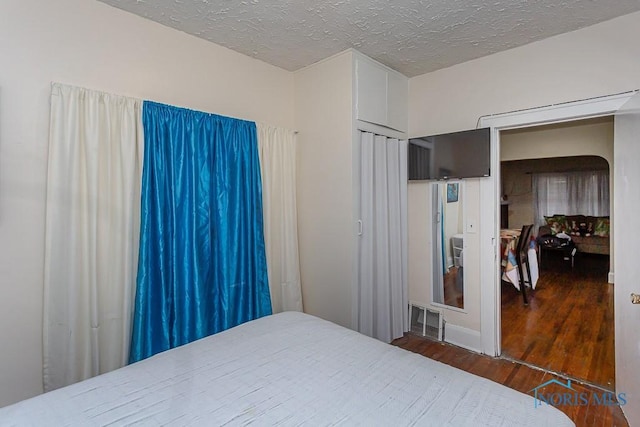 bedroom with dark wood-type flooring and a textured ceiling