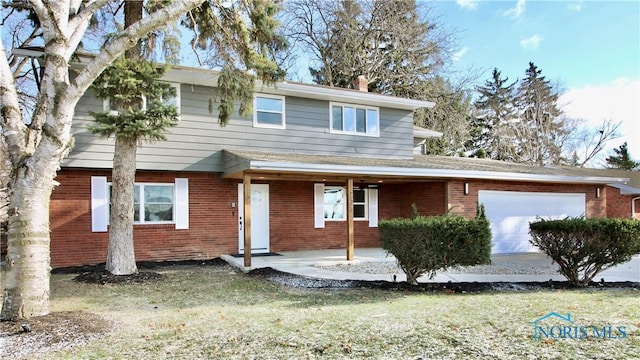 view of property featuring a garage and a front lawn