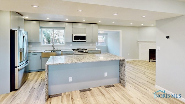 kitchen with a wealth of natural light, stainless steel appliances, and a kitchen island