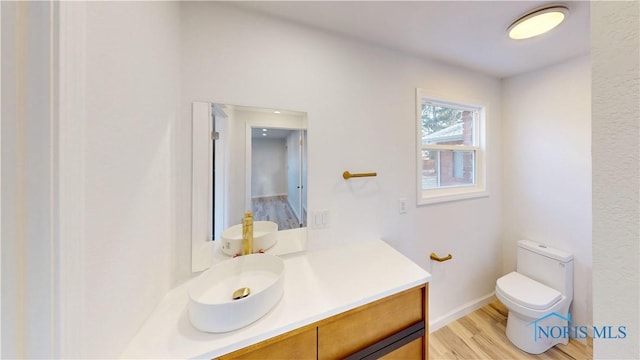 bathroom with vanity, toilet, and hardwood / wood-style floors