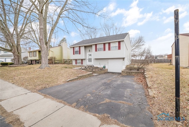 bi-level home featuring a garage and a front yard