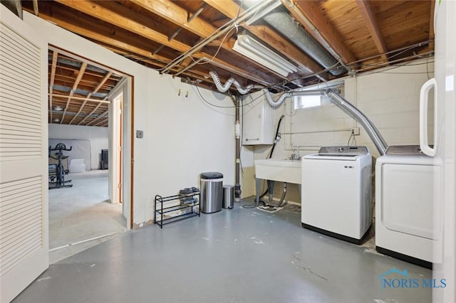 basement featuring independent washer and dryer and sink