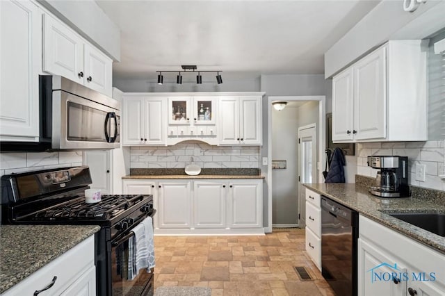 kitchen with sink, white cabinetry, black appliances, dark stone countertops, and backsplash