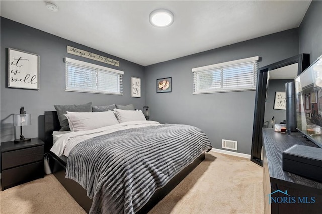 bedroom featuring light carpet and multiple windows