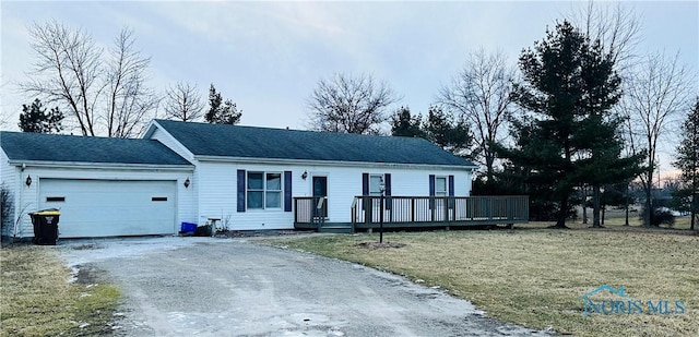 view of front facade featuring a garage, a front lawn, and a deck