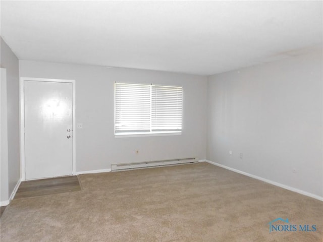 unfurnished room with a baseboard heating unit and light carpet