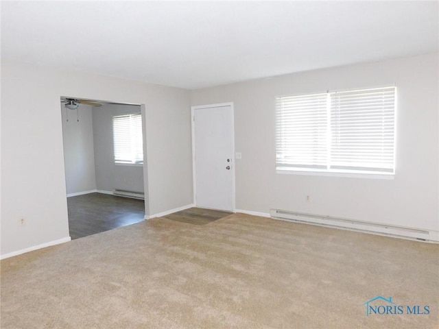 unfurnished room with a baseboard heating unit, light carpet, and ceiling fan