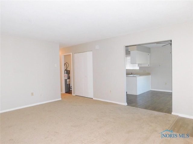 carpeted spare room featuring water heater