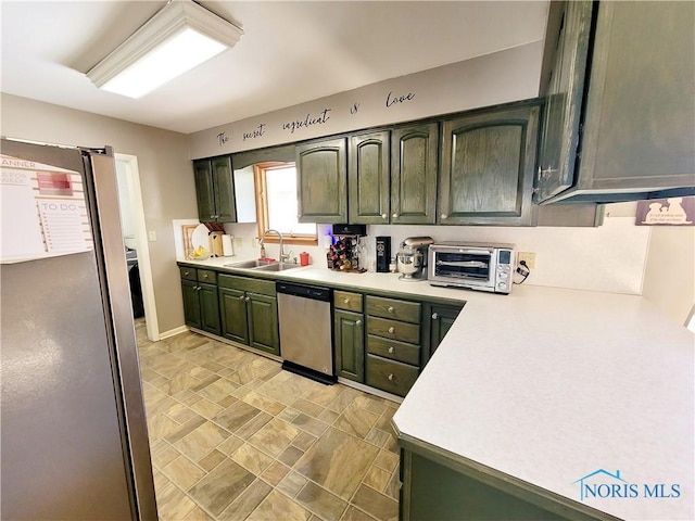 kitchen with sink, stainless steel appliances, and green cabinetry