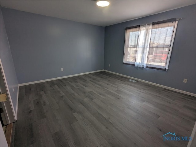 spare room featuring dark wood-type flooring