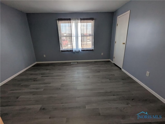 spare room with dark wood-type flooring