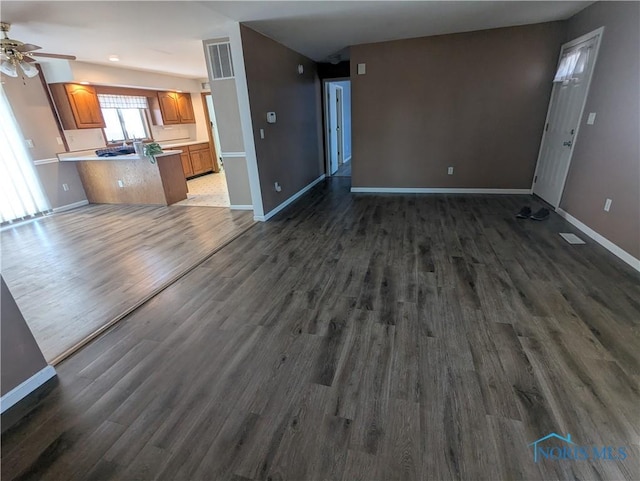 unfurnished living room with ceiling fan and dark hardwood / wood-style flooring