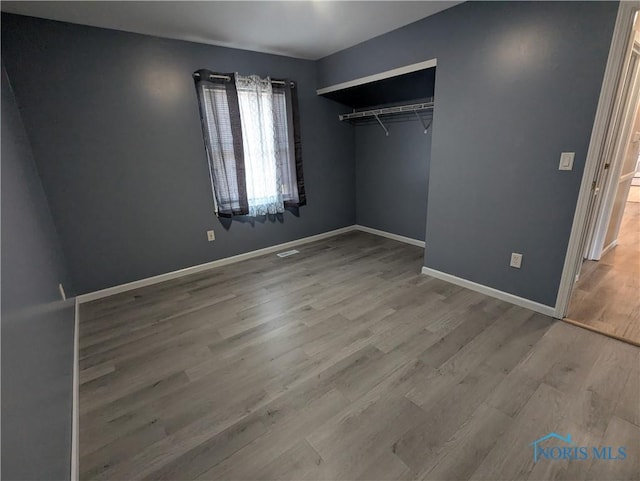 unfurnished bedroom featuring light hardwood / wood-style flooring and a closet