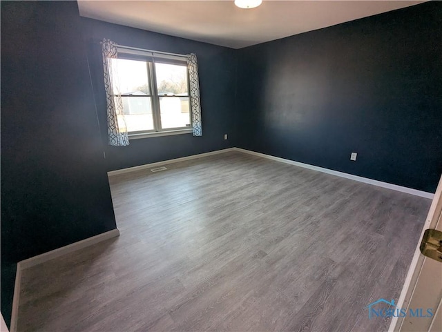 spare room featuring wood-type flooring