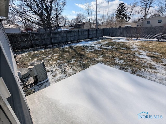 yard layered in snow featuring central AC unit