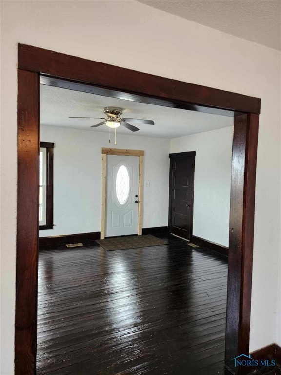 foyer entrance featuring dark wood-type flooring and ceiling fan