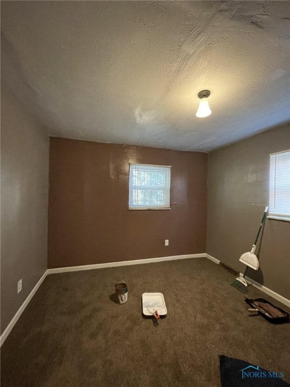 carpeted empty room with a textured ceiling