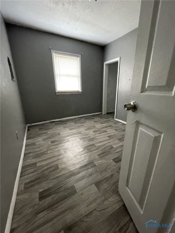 1455 Oak St, Toledo, OH 43605 - unfurnished bedroom featuring a textured ceiling, baseboards, and wood finished floors