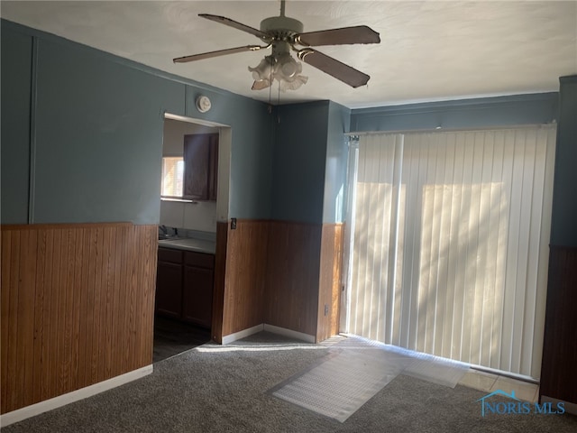 1455 Oak St, Toledo, OH 43605 - spare room featuring a wainscoted wall, carpet floors, a sink, a ceiling fan, and wood walls