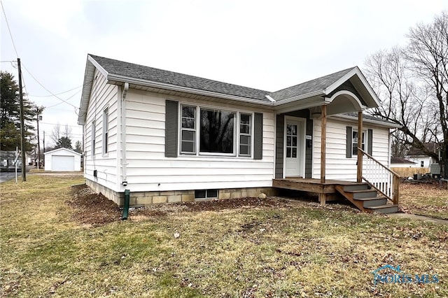 view of front of home featuring a garage, an outdoor structure, and a front yard