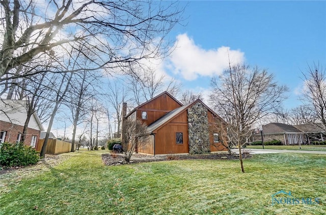 view of side of home with a yard